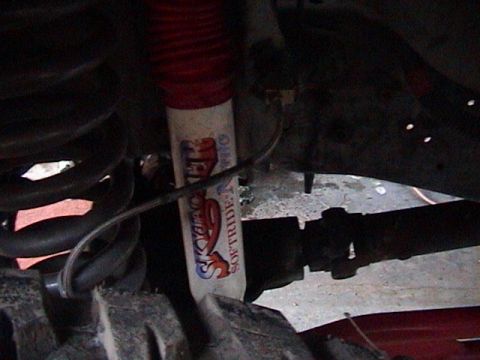 1990 Ford Bronco - Close-up of a Skyjacker Softride shock absorber and suspension components, likely from an off-road vehicle.