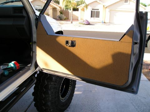 1986 Toyota Hilux - The interior door panel and a large off-road tire are visible on this vehicle.
