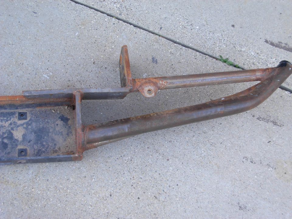 Rusted metal part with mounting brackets and tubular frame