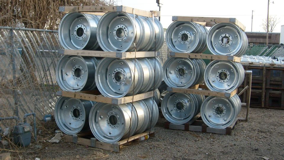 Stacks of silver metal wheels on wooden pallets