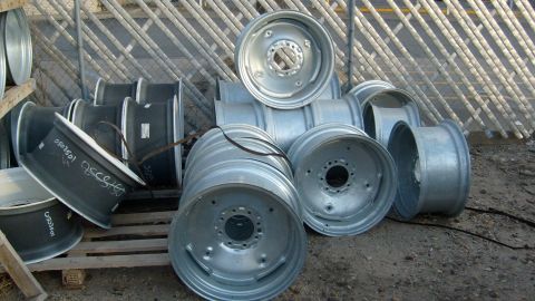 1995 Ford C-350 (Centurion Conversions) - Several truck wheels are piled up in an outdoor storage area.