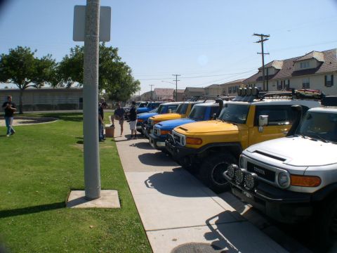 2007 Toyota FJ Cruiser - Multiple Toyota FJ Cruisers are parked in a row on a sidewalk.