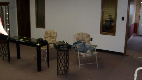 1995 Ford C-350 (Centurion Conversions) - An indoor scene shows two chairs, a console table, and a mirror reflecting a person.