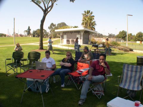 2007 Toyota FJ Cruiser - A group of people are gathered in a park on a sunny day, with a building and trees in the background.
