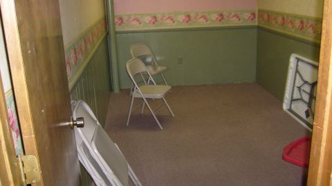 1995 Ford C-350 (Centurion Conversions) - An indoor scene shows a room with chairs and a table, devoid of any vehicles.
