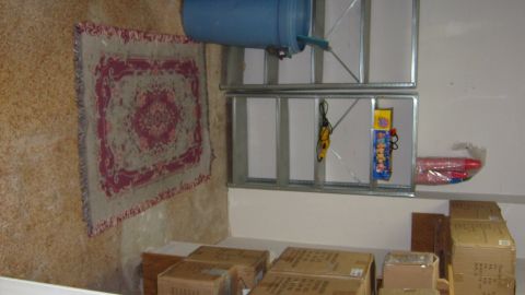 1995 Ford C-350 (Centurion Conversions) - A cluttered interior scene shows storage shelves with various items including a blue barrel, a rug, and stacked boxes.