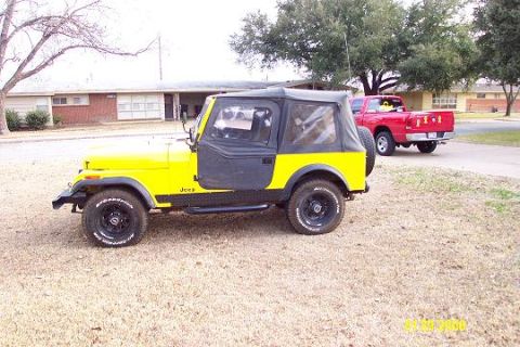 1981 Jeep CJ7 - A yellow 1981 Jeep CJ7 is parked on dry grass, with a red pickup truck in the background.