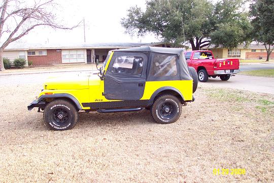 Yellow 1981 Jeep CJ7 with black soft top and doors, parked on dry grass