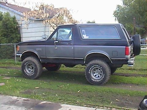 1990 Ford Bronco - Side view of a lifted 1990 Ford Bronco with aftermarket wheels and tires.