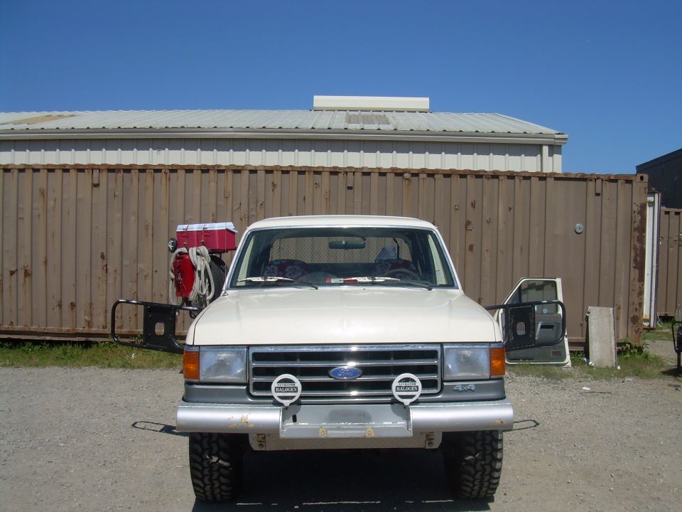White 1991 Ford Bronco front view with aftermarket bumper and driving lights
