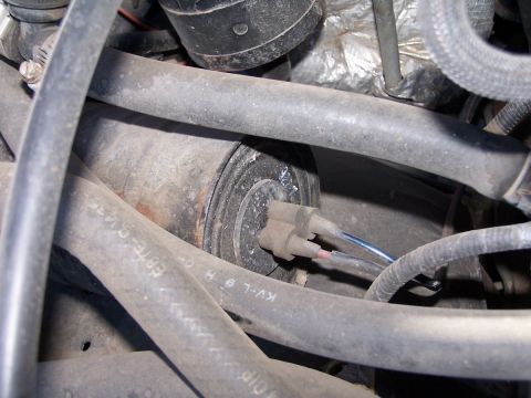 1990 Ford Bronco - Close-up view of an engine component with connected wires and surrounding hoses.