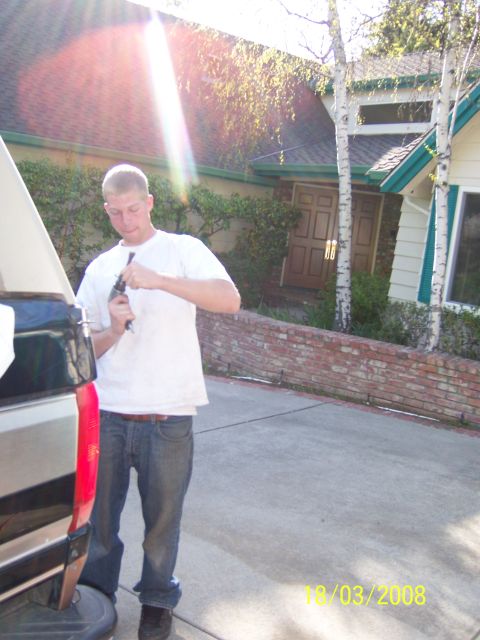 1991 Ford Bronco - A man works on the rear of a pickup truck in a driveway on 10/03/2008.