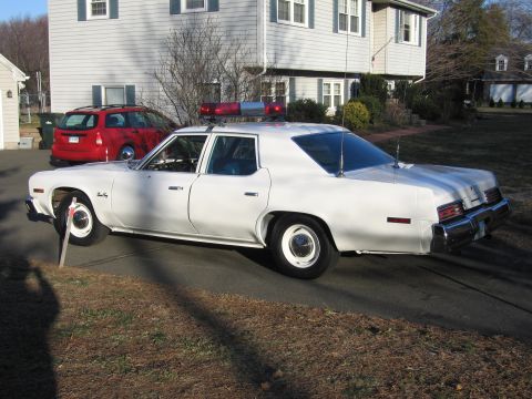 1991 Ford Crown Victoria LTD - A white sedan with a light bar on the roof is parked in a driveway next to a red SUV.