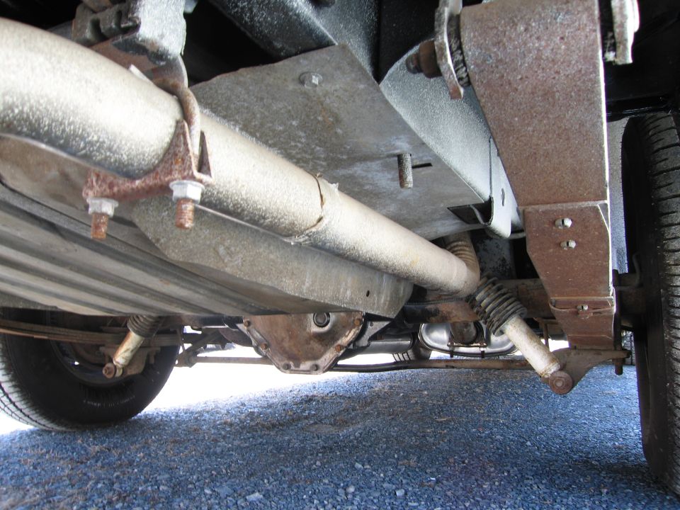 Undercarriage view of a car showing the exhaust system, differential, and leaf springs