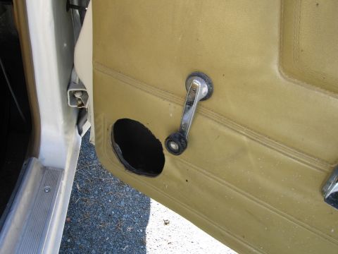 1991 Ford LTD Crown Victoria - Interior view of a car door panel showing a manual window crank and a speaker cutout.