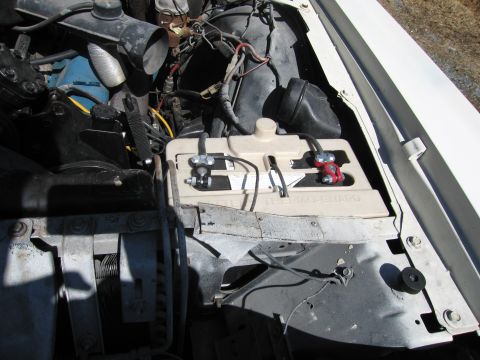 1991 Ford LTD Crown Victoria - Close-up view of a car's engine bay, focusing on the battery and surrounding components.