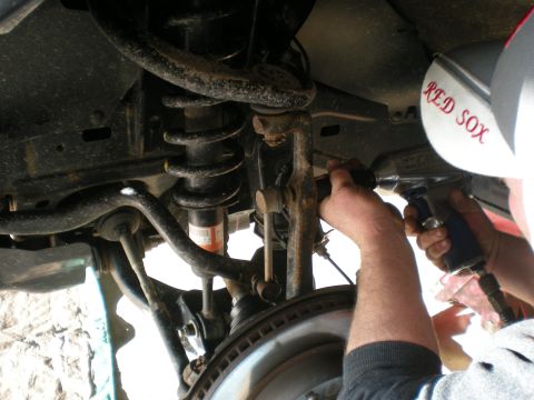 2007 Toyota Land Cruiser - Mechanic uses an impact wrench to work on the vehicle's suspension system.