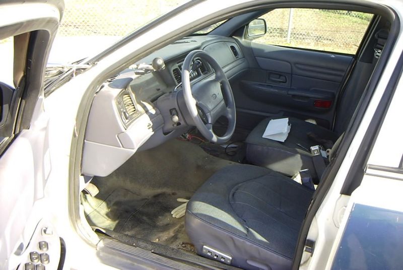 Gray cloth interior driver seat and steering wheel of a Ford sedan