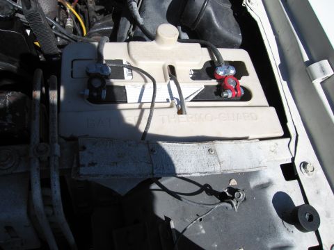 1991 Ford LTD Crown Victoria - Close-up view of a car battery and its terminals under the hood.