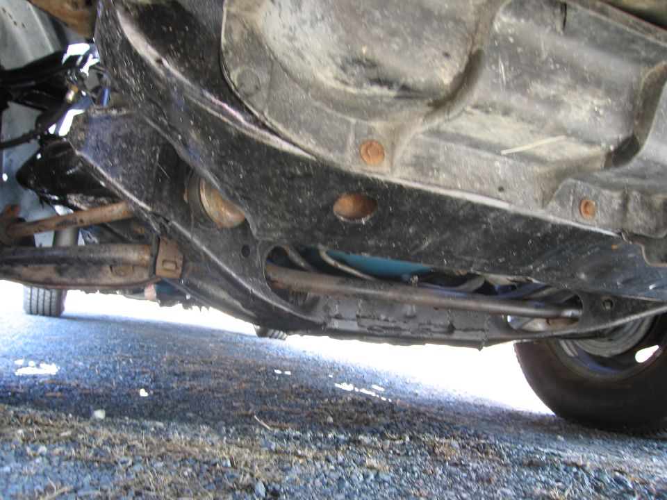 Undercarriage view showing suspension components and frame of a vehicle