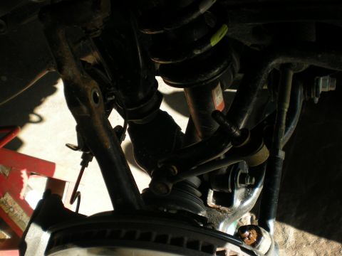 2007 Toyota Land Cruiser - Close-up view of vehicle suspension components, with a red jack stand in the background.