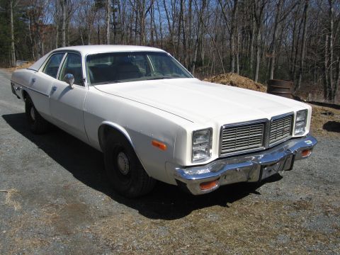 1991 Ford LTD Crown Victoria - A white 1977 Dodge Monaco sedan is parked outdoors on a gravel surface, with trees in the background.