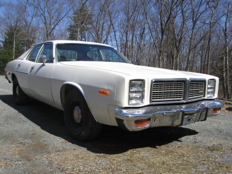1991 Ford LTD Crown Victoria - This 1977 Dodge Monaco sedan is seen from the front quarter angle, parked outdoors on a gravel surface.