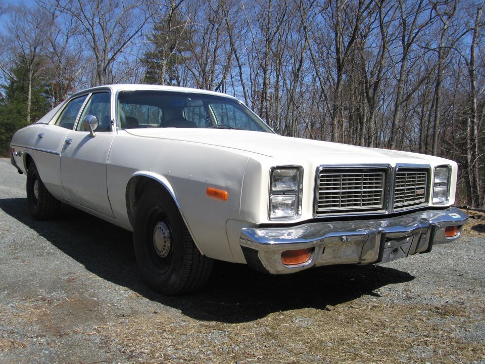 1977 Dodge Monaco sedan, front quarter view, parked on gravel with trees in background