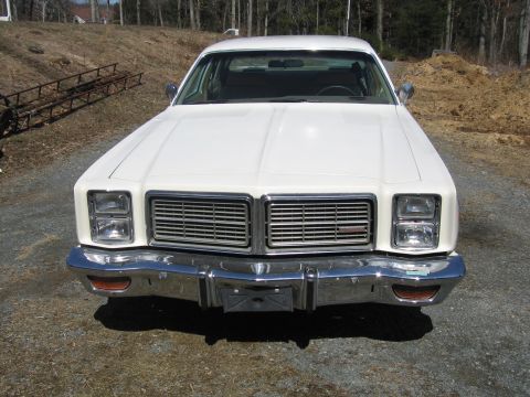 1991 Ford LTD Crown Victoria - 1977 Chevrolet Caprice Classic sedan front view. The grille and headlight design are distinctive.