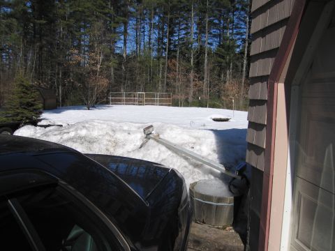 1991 Ford LTD Crown Victoria - A black car is parked in front of a garage with snow piled high in the yard.