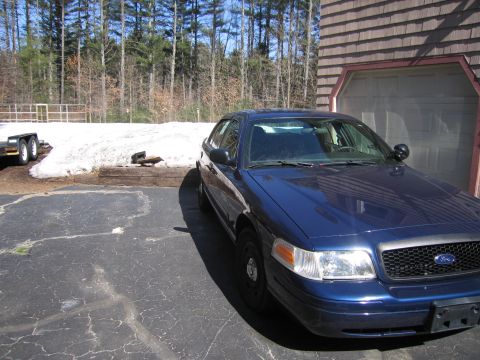 1991 Ford LTD Crown Victoria - This 1991 Ford Crown Victoria LTD sedan, equipped with a police spotlight, is parked in a driveway next to a garage.