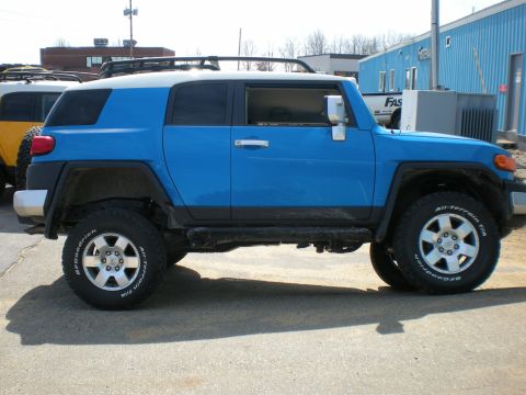 2007 Toyota Land Cruiser - A blue Toyota FJ Cruiser is shown from the side, parked next to another vehicle.