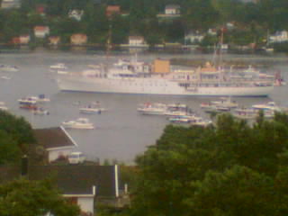 1972 Ford Ranchero - A large white ship is seen in a harbor surrounded by smaller boats and land.