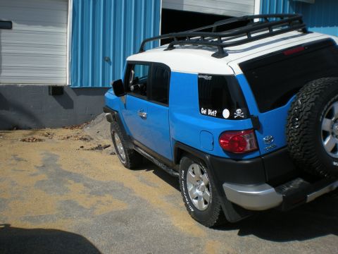 2007 Toyota Land Cruiser - Blue and white 2007 Toyota FJ Cruiser with roof rack and spare tire.