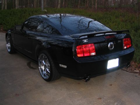 2007 Ford Mustang - Rear view of a black 2007 Ford Mustang coupe with a spoiler and chrome wheels.