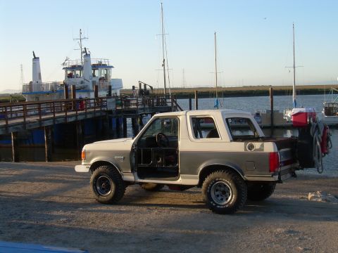 1991 Ford Bronco - This 1991 Ford Bronco is parked near a body of water with several boats and a ferry visible.