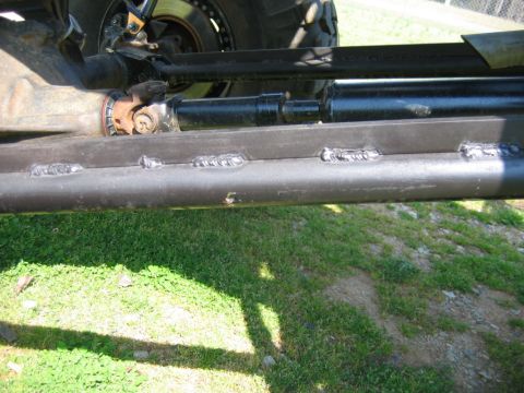 1992 Ford Mustang - Close-up view of a vehicle's undercarriage, showing welded metal components and part of the suspension system.