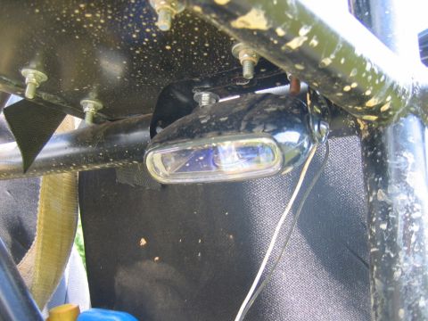1992 Ford Mustang - Close-up of a black aftermarket light attached to a vehicle's roll cage structure.