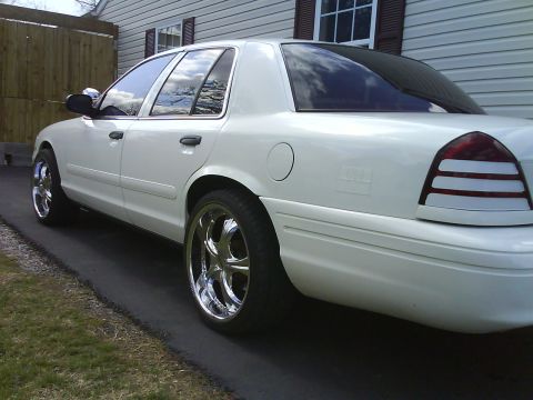 2003 Ford Crown Victoria - Rear quarter view of a white 2003 Ford Crown Victoria with custom chrome wheels.