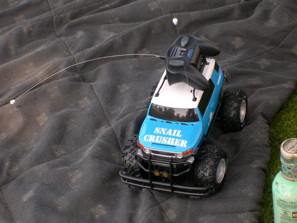 RC toy truck with 'SNAIL CRUSHER' on the hood, sitting on a blanket