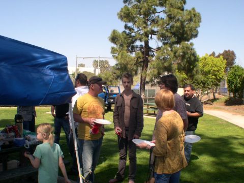 2007 Toyota FJ Cruiser - A blue SUV is visible in the background of a casual outdoor event with several people.