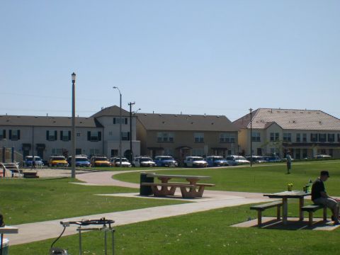 2007 Toyota FJ Cruiser - A variety of vehicles are parked in front of residential buildings on a sunny day.