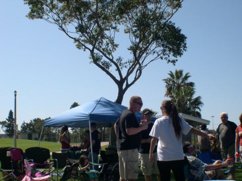 2007 Toyota FJ Cruiser - A group of people are socializing outdoors under a blue canopy on a sunny day.