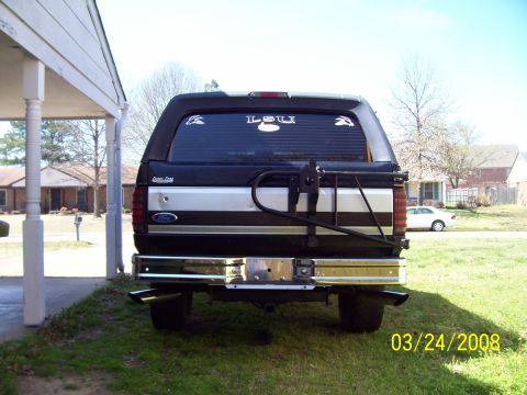 1994 Ford Bronco - Rear view of a black Ford Bronco with a chrome bumper and dual exhaust pipes.