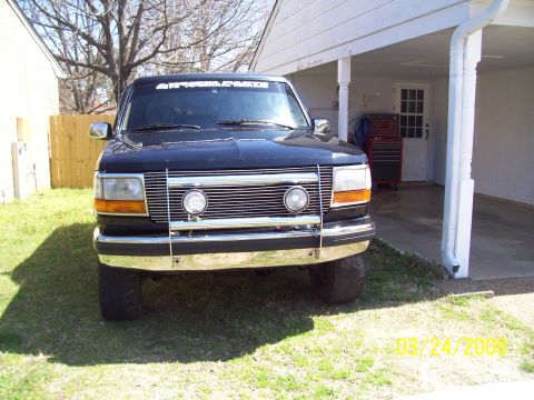 1994 Ford Bronco - This black 1994 Ford Bronco is seen from the front, a prominent chrome grille and bumper.