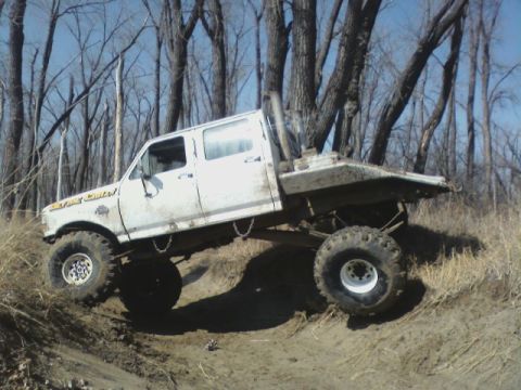 1992 Ford F-350 - This modified 1992 Ford F-350 crew cab navigates rough terrain with its lifted suspension and flatbed.