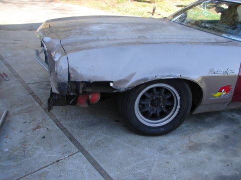 1973 Ford Ranchero - Front left quarter of a Ranchero Squire in bare primer and body filler on a concrete driveway, with the front bumper, headlight and inner f…