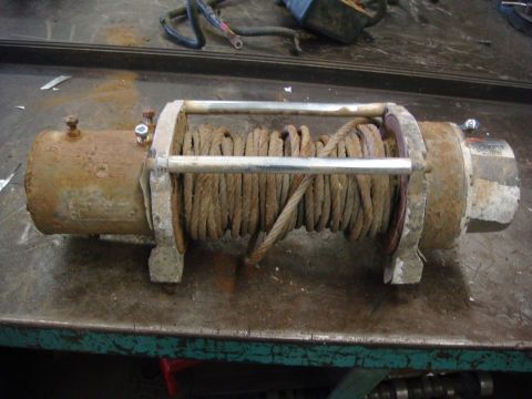 1996 Ford Bronco - A weathered winch sits on a metal surface, showing signs of age and use.