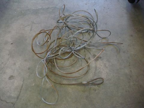 1996 Ford Bronco - A tangled winch cable lies coiled on a concrete surface, showing signs of rust and wear.