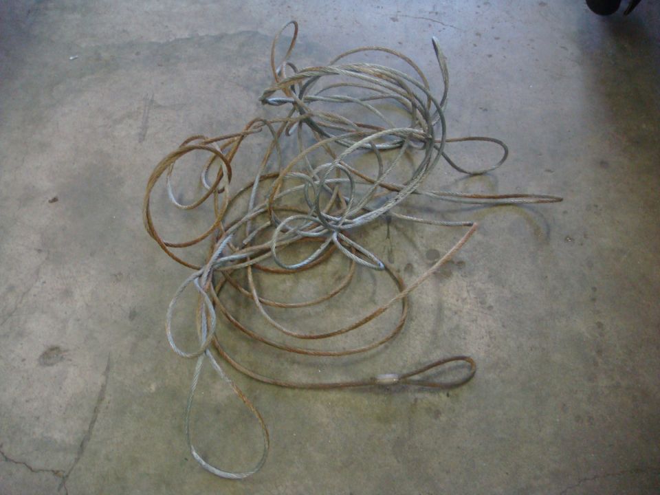 Tangled winch cable with looped ends on concrete floor